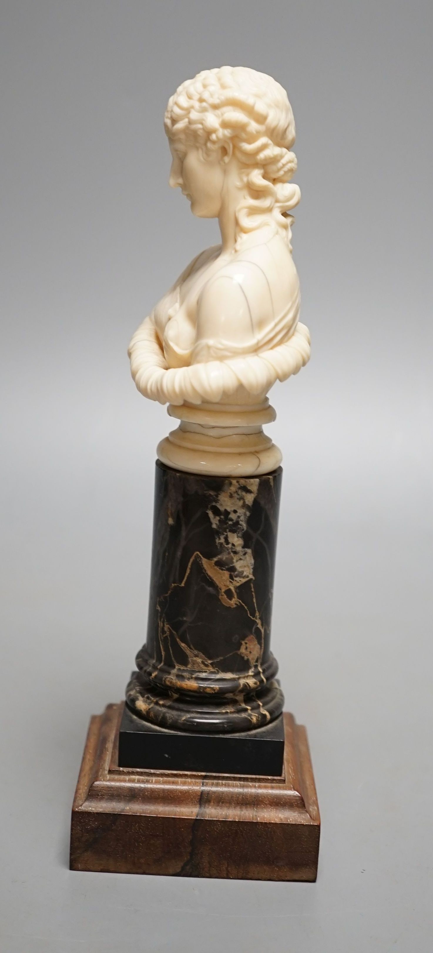 A 19th-century Dieppe ivory bust of Clytie, on a marble and rosewood pedestal, after the model in the British Museum - 24.5cm tall